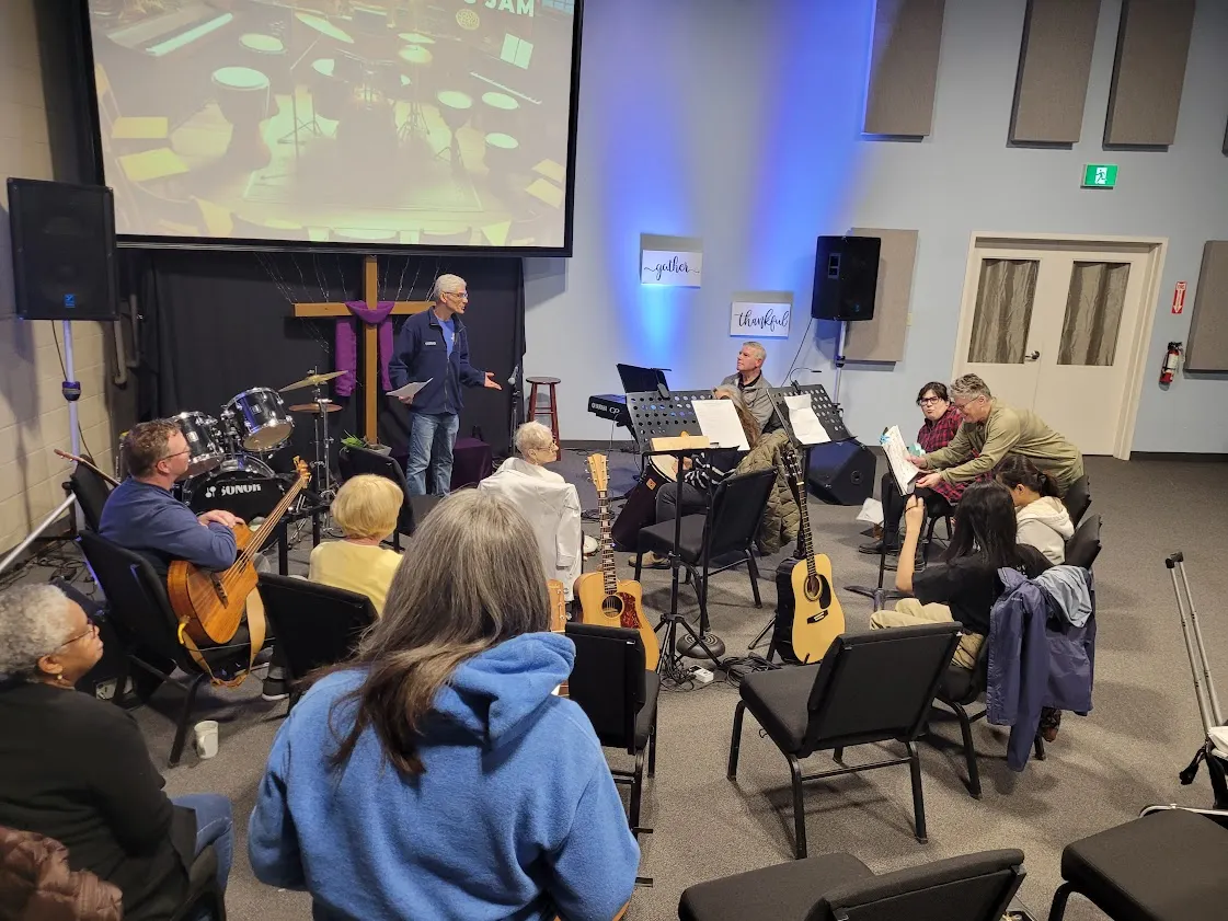 A group of musicians sit in a circle for a musical jam evening