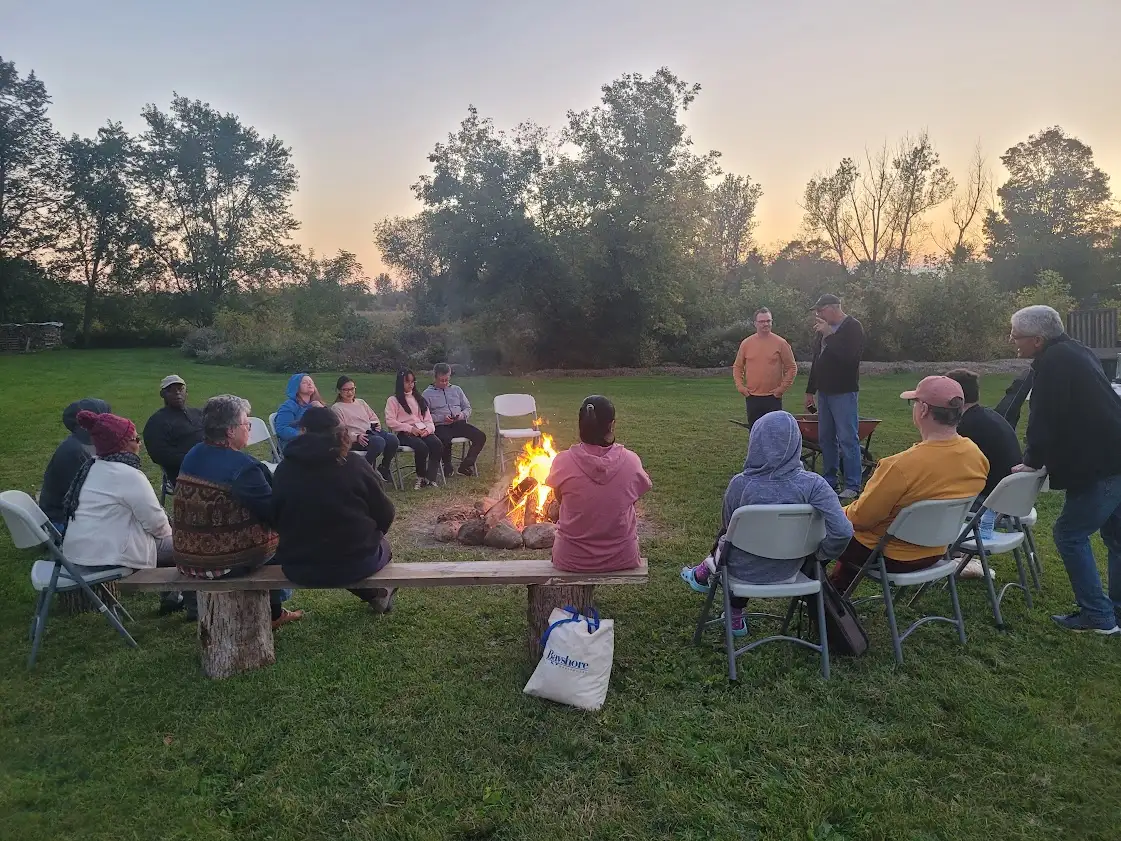 A group of people sit around a campfire