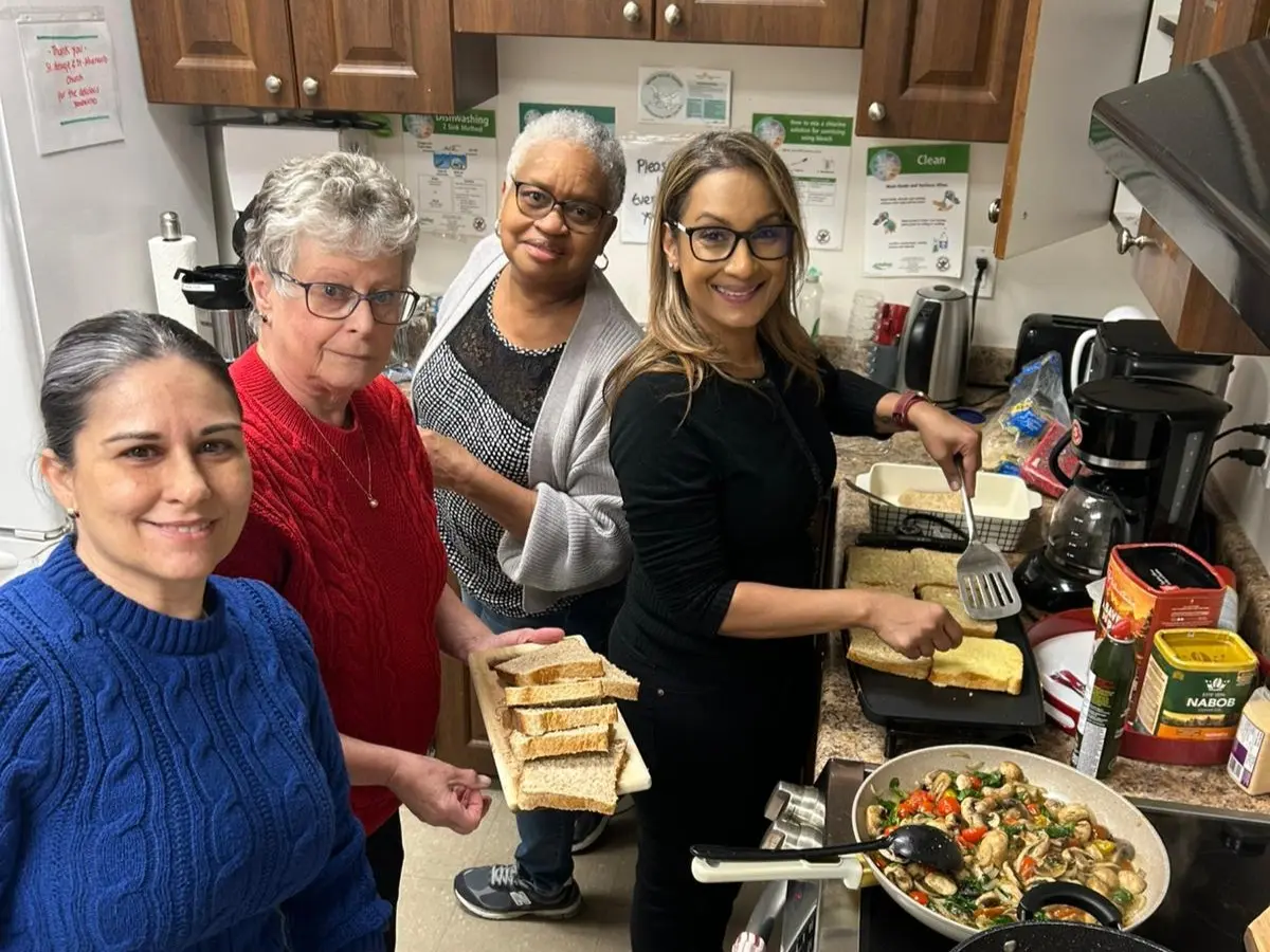 A group of women prepare food in the kitchen