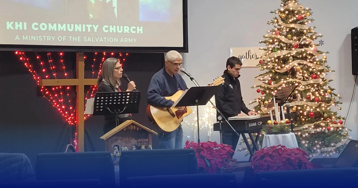 A three-person worship team practices before a Christmas Advent church service